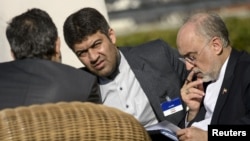 The head of Iranian Atomic Energy Organization Ali Akbar Salehi (R) looks over papers before meetings at the Beau Rivage Palace Hotel March 28, 2015 in Lausanne. 