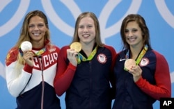 United States' gold medal winner Lilly King is flanked by Russia's silver medal winner Yulia Efimova, left, and United States' bronze medal winner Katie Meili during the ceremony for the women's 100-meter breaststroke final during the swimming competitions at the 2016 Summer Olympics, Tuesday, Aug. 9, 2016.