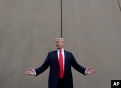 FILE - President Donald Trump speaks during a tour as he reviews border wall prototypes in San Diego, March 13, 2018.