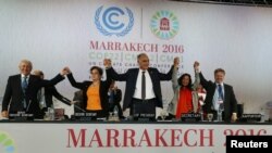 U.N. climate chief Patricia Espinosa, second left, Morocco's Foreign Minister Salaheddine Mezouar, center, and Council of Europe Goodwill Ambassador Bianca Jagger, second right, celebrate after the proclamation of Marrakech, at the U.N. World Climate Chan
