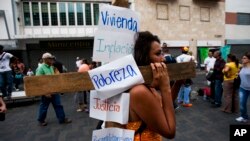 Una manifestante antigubernamental lleva una cruz con sus reclamos al gobierno, durante el viacrucis del venezolano, celebrado ayer en Caracas.