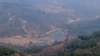 位于中缅边境大山里的克钦难民营（蓝色屋顶）。从中国境内一侧拍摄。（美国之音朱诺拍摄，2015年3月16日）