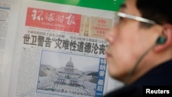 北京街头一个报刊亭中展示环球时报的头版头条，照片为美国总统拜登就职典礼时的国会大厦全景。（2021年1月21日） 