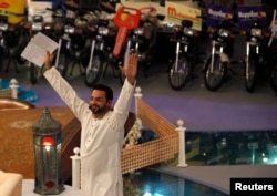 FILE - Aamir Liaquat Hussain, host of the Geo TV channel program "Amaan Ramazan," gestures while asking participants questions during a live show in Karachi, July 26, 2013.