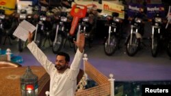 Aamir Liaquat Hussain, host of the Geo TV channel program "Amaan Ramazan", gestures while asking participants questions during a live show in Karachi, July 26, 2013. 
