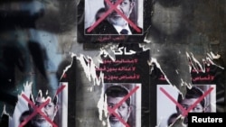 FILE - Torn posters of ousted Egyptian president Mohamed Morsi are seen on a wall at Tahrir Square in Cairo.