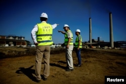 Chinese employees of Shanghai Electric company supervise the construction site of a biomass power station in Ciro Redondo, Cuba, Feb. 9, 2017.