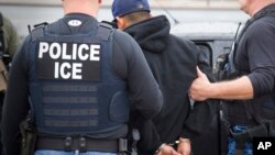 FILE - This Feb. 7, 2017, photo released by U.S. Immigration and Customs Enforcement shows foreign nationals being arrested during an operation aimed at immigration fugitives, re-entrants and at-large criminal aliens in Los Angeles.