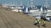 Patrulha de segurança passa por barcos da EMATUM na doca de Maputo.