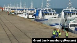 Patrulha de segurança passa por barcos da EMATUM na doca de Maputo.