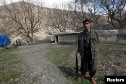 FILE - A Kurdistan Workers' Party (PKK) fighter stands guard at the Qandil mountains near the Iraq-Turkish border in Sulaimaniya, 330 km (205 miles) northeast of Baghdad, March 24, 2013.