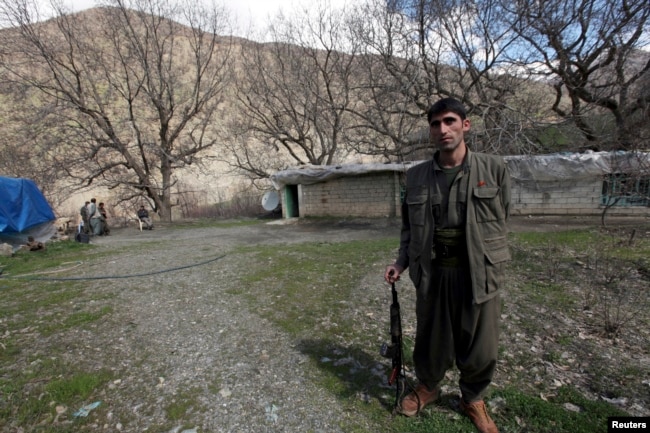 FILE - A Kurdistan Workers' Party (PKK) fighter stands guard at the Qandil mountains near the Iraq-Turkish border in Sulaimaniya, 330 km (205 miles) northeast of Baghdad, March 24, 2013.