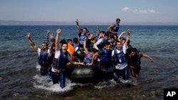 Un bateau pneumatique plein des réfugiés et migrants accostent sur la rive à l'ïle de Lesbos, en Grèce, 11 septembre 2015.