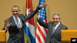 FILE - Cuban President Raul Castro, right, lifts up the arm of President Barack Obama, at the conclusion of their joint news conference at the Palace of the Revolution, in Havana, Cuba, March 21, 2016.