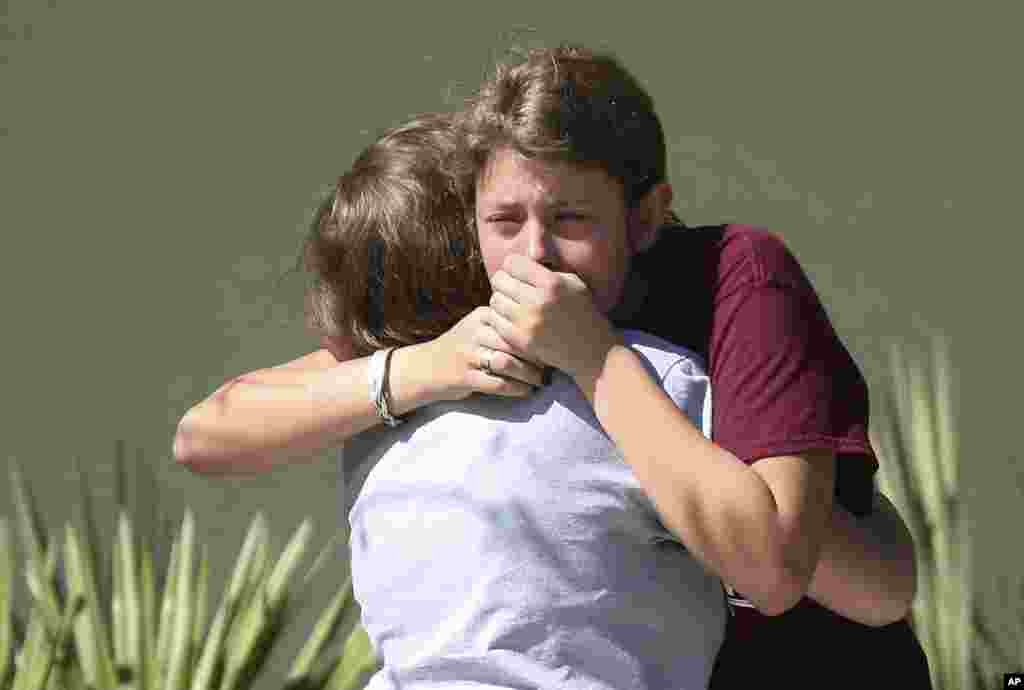 Students grieve outside Pines Trail Center where counselors are present, after Wednesday's mass shooting at Marjory Stoneman Douglas High School in Parkland, Florida. Nikolas Cruz was charged with 17 counts of premeditated murder.
