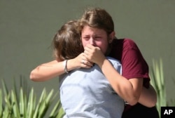 Students grieve outside Pines Trail Center where counselors are present, after Wednesday's mass shooting at Marjory Stoneman Douglas High School in Parkland, Florida, Feb. 15, 2018.