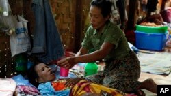 FILE - A family member takes care of a HIV patient at HIV/AIDS care center founded by Phyu Phyu Thin, a parliament member of Myanmar Opposition Leader Aung San Suu Kyi's National League for Democracy Party, in outskirts of Yangon, Myanmar.