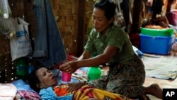 A family member takes care of a HIV patient at a HIV/AIDS care center outside Yangon, Myanmar, February 2015. The World Health Organization estimates that 39 million people died from the virus. (AP Photo/Khin Maung Win)