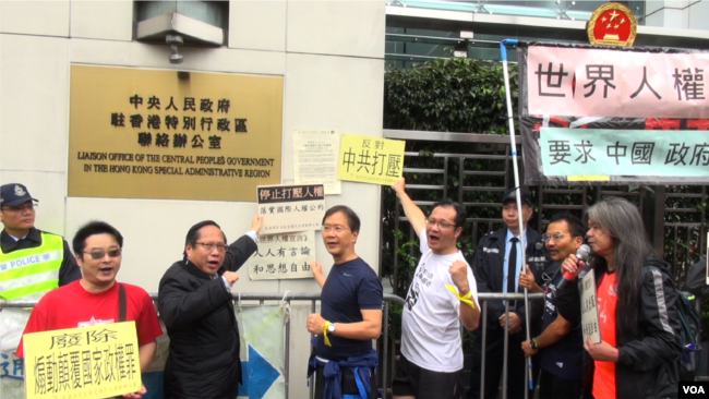 集会人士把游行宣言抗议信贴到香港中联办铜牌的旁边（美国之音谭嘉琪）