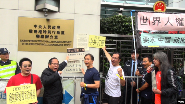 集会人士把游行宣言抗议信贴到香港中联办铜牌的旁边(美国之音谭嘉琪)