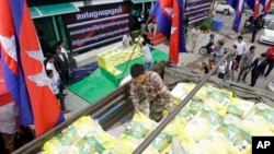 A worker unloads sacks of rice from a truck during a campaign organized by a private company for selling lower price of rice, in Phnom Penh, Cambodia, Saturday, Sept. 24, 2016. Cambodian farmers in northwestern Battambang province, recently piled up a hun