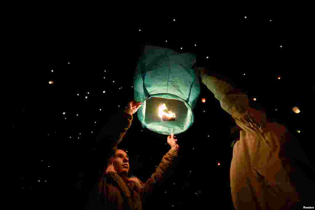 Orang-orang melepaskan lampion ke langit selama perayaan Natal di Volos, Yunani.