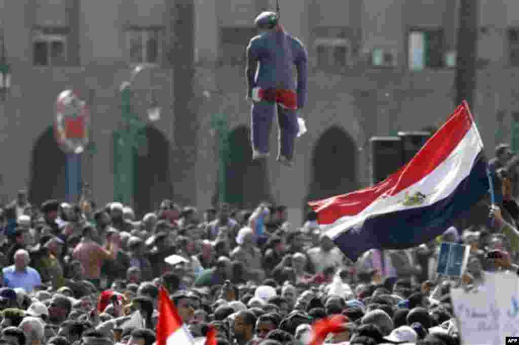 Egyptian protesters wave Egyptian flags under an effigy representing a hanged President Mubarak during a protest in Tahrir square in Cairo, Egypt, Friday, Feb.4, 2011. The Egyptian military guarded thousands of protesters pouring into Cairo's main square