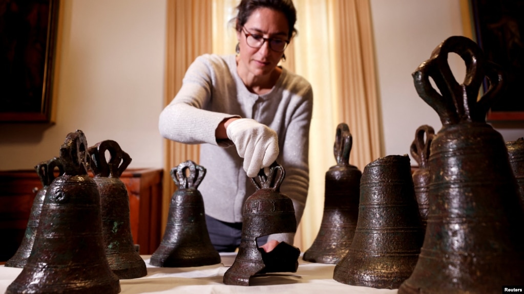 Estelle Ingrand-Varenne, researcher at the Centre de recherche francais a Jerusalem arranges bells from the 12th century that researchers say used to play music inside Bethlehem's Church of the Nativity. Picture taken December 14, 2021. (REUTERS/Amir Cohen)