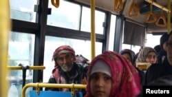Evacuados de aldeas musulmanas chiítas en un bus en la provincia de Alepo.