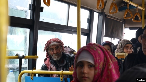 Evacuados de aldeas musulmanas chiítas en un bus en la provincia de Alepo.