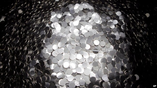 FILE - Unmarked 5-cent coins sit in a pile after being cut from a coil at the US Mint on June 27, 2012, in Philadelphia.