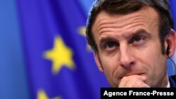 FILE - French President Emmanuel Macron looks on during a joint press conference with Germany's Chancellor Olaf Scholz (out of frame) during an European Union (EU) summit at the European Council Building at the EU headquarters in Brussels, Dec. 17, 2021