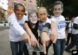 Anti-globalization members wearing masks, from left, of US President Barack Obama, German Chancellor Angela Merkel, Vladimir Putin Prime Minister of Russia and French President Nicolas Sarkozy demonstrate in Nice, southeastern France, against G20 summit