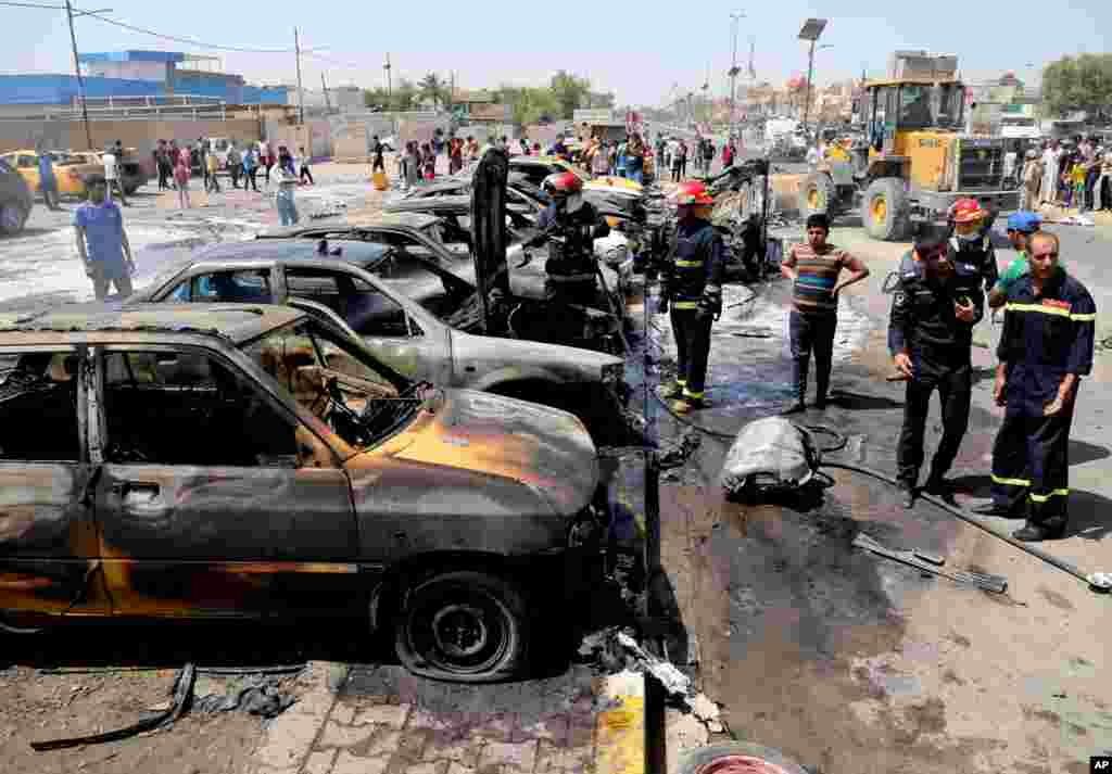 Firefighters extinguish vehicles after a car bomb explosion in the Shi'ite stronghold of Sadr City, Baghdad, May 13, 2014.