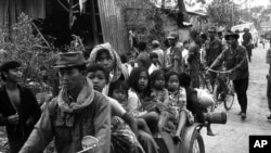 Cambodian women and children fill the back of a motorcycle taxi carrying them to safer parts of Phnom Penh as Khmer Rouge insurgents continue their artillery shellings of the capital, Jan. 28, 1974.