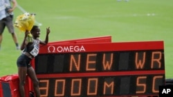 Ruth Jebet, de Bahreïn, pose à côté du tableau indiquant son record du monde dans l'épreuve féminine du 3000 mètres lors de la Ligue de diamant au Stade de France à Saint Denis, le 27 août 2016.