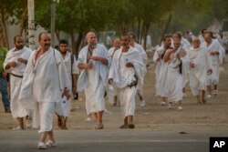 Peregrinos musulmanes caminan hacia la mezquita de Namirah en la montaña Arafat, durante la peregrinación anual del Hach, a las afueras de la ciudad sagrada de La Meca, Arabia Saudita, el domingo 19 de agosto de 2018.