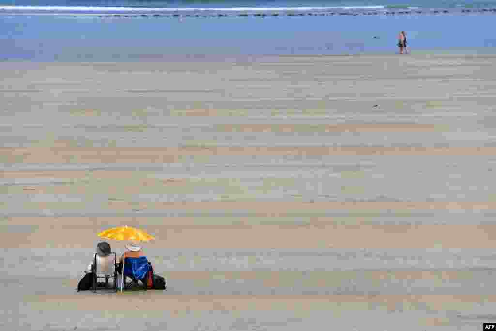 Pengunjung menikmati hari cerah di pantai Saint-Malo, Perancis barat.