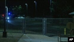 Lights from security personnel vehicles are seen in a screen grab from video outside the gate at Joint Base Myer-Henderson Hall, Arlington, Virginia, Feb. 27, 2018.