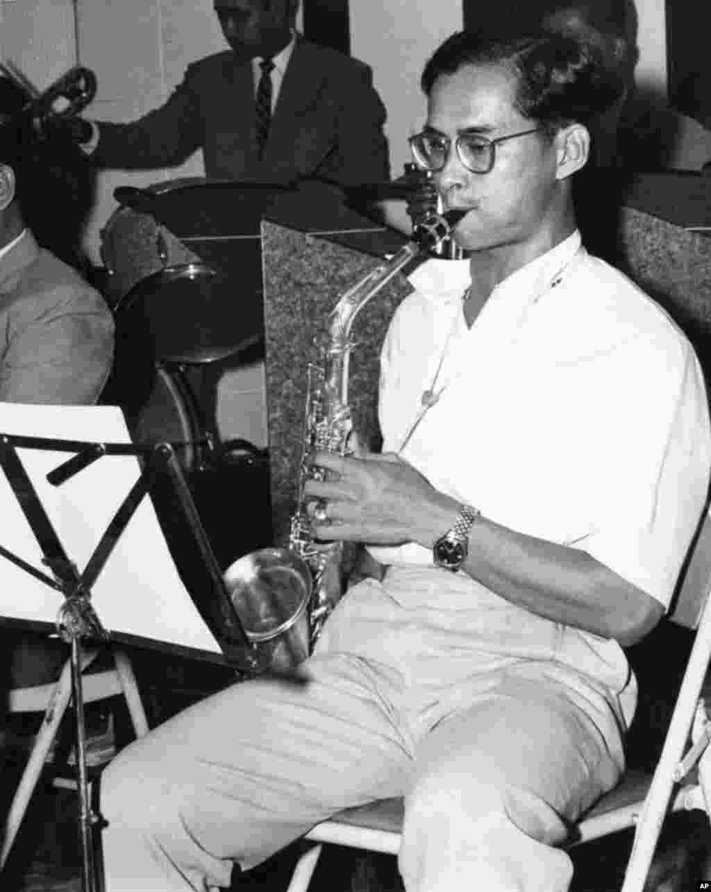King Bhumibol Adulyadej clad in sports shirt and slacks, swings into a hot chorus on the alto sax with his 13-piece jazz band, Nov. 13, 1962.