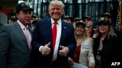 Republican presidential candidate Donald Trump poses for a picture with supporters at the end of a press conference with members of the New York Veteran Police Association in Staten Island, New York.