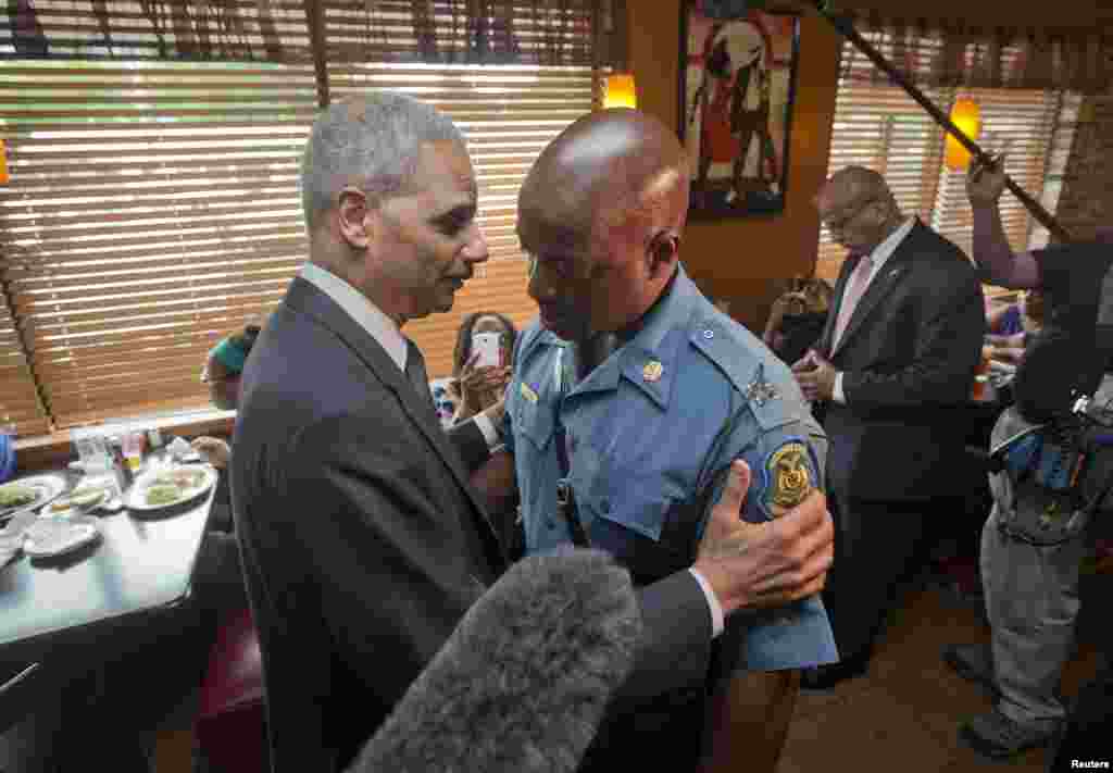 Attorney General Eric Holder greets Capt. Ron Johnson of the Missouri State Highway Patrol at Drake&#39;s Place Restaurant in Florissant, Missouri Aug. 20, 2014.