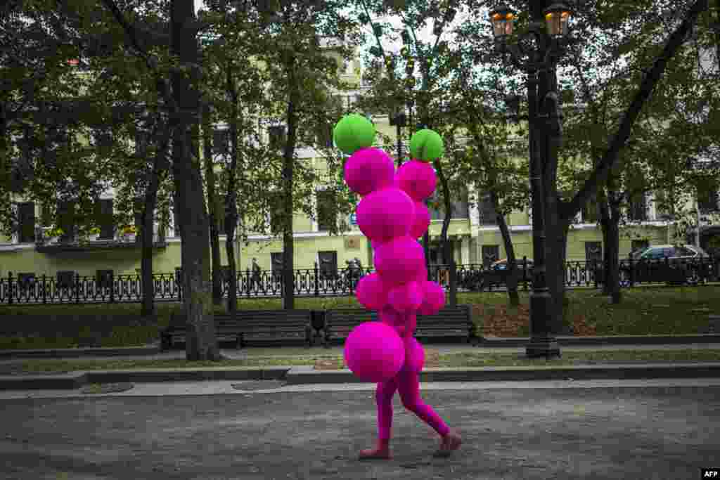A circus performer walks through a park in downtown Moscow, Russia, September 15, 2019.