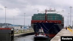 FILE - A floating gate is opening to the Chinese COSCO container vessel named Andronikos navigating through the Agua Clara locks during the first ceremonial pass through the newly expanded Panama Canal in Agua Clara, on the outskirts of Colon City, Panama.