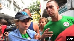 Anastasia Vashukevich and Alex Kirillov leave the Thai immigration department in Bangkok, Jan. 17, 2019, during their deportation together with other associates after pleading guilty in court to multiple charges, including solicitation and illegal assembly.