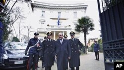 Greek ambassador to Italy Michael E. Cambanis (2nd R) is flanked by Carabinieri officers as he walks off the Greek Embassy in Rome, 27 Dec 2010