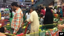 People are seen buying essential food staples at a supermarket in Doha, Qatar, Monday, June 5, 2017. Fears about food shortages came after some Gulf nations ended diplomatic relations with Qatar.