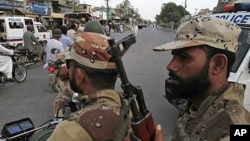 In this picture taken Aug. 1, 2011, Pakistani paramilitary troops patrol a troubled area of Karachi, Pakistan, following weeks of unabated killings
