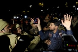 An Indian student, bleeding from head, raises his hands as he is detained by police during a protest march towards the presidential palace against a recent attack on students by masked men inside Jawaharlal Nehru University, in New Delhi, India, Thursday,