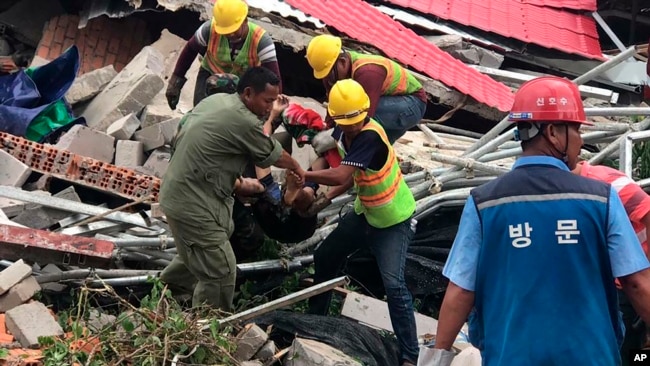 Rescatistas sacan un cuerpo de entre los escombros de un edificio derrumbado en la provincia de Preah Sihanouk, en Camboya, el 22 de junio de 2019. (Nokorwat News via AP)